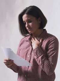 young woman reading sheet of paper