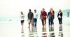 a group of young adults walking on the beach