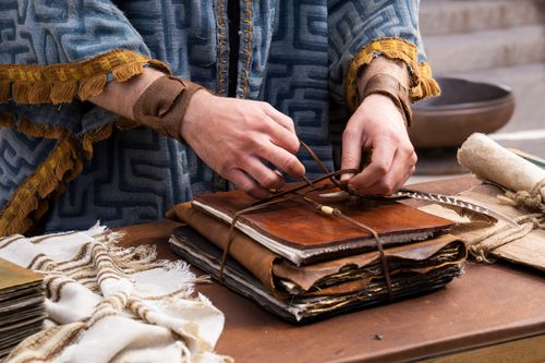 King Mosiah begins to open a book containing the records of the people of Zeniff.