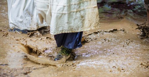 young woman walking through mud