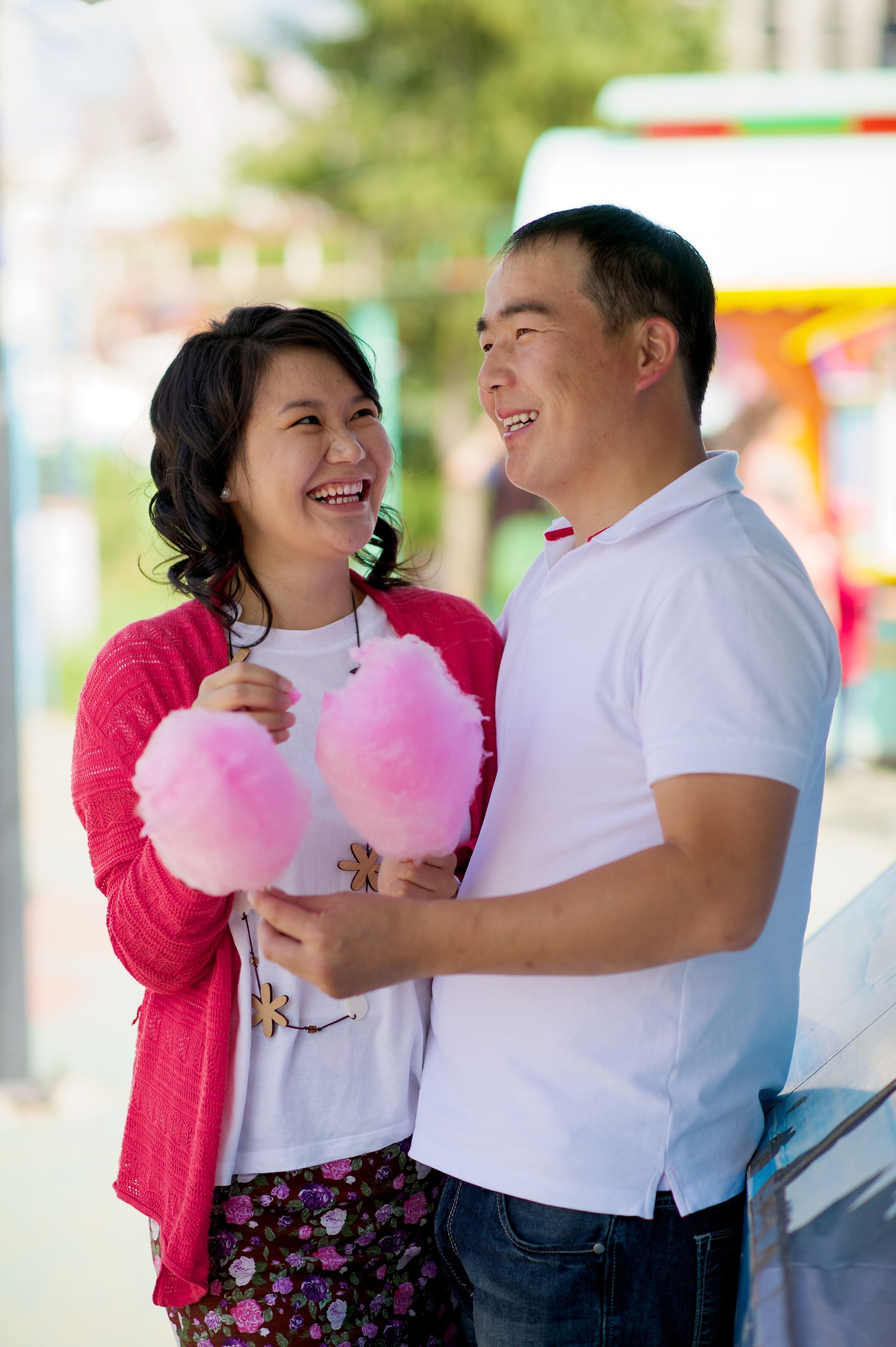 A couple at a carnival, holding cotton candy.