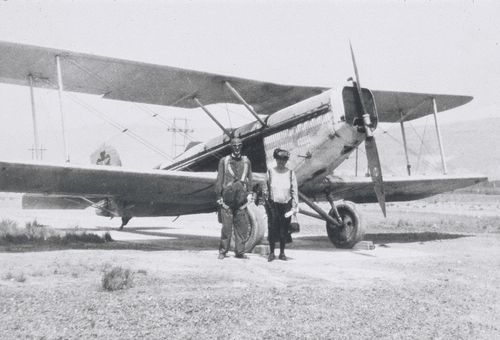 George Albert Smith in aviator clothes, standing by his wife, Lucy Smith, in front of an airplane.