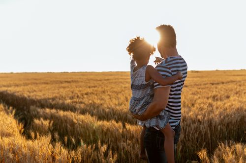 father and daughter watching a sunset