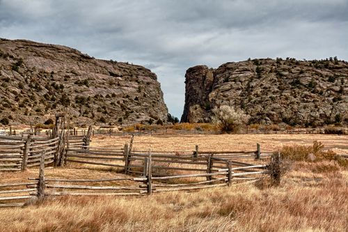 A field with a wooden fence and brush near Devil’s Gate in Wyoming.