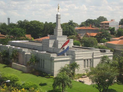 The Asunción Paraguay Temple seen among the surrounding community, with the Paraguayan flag in the foreground.