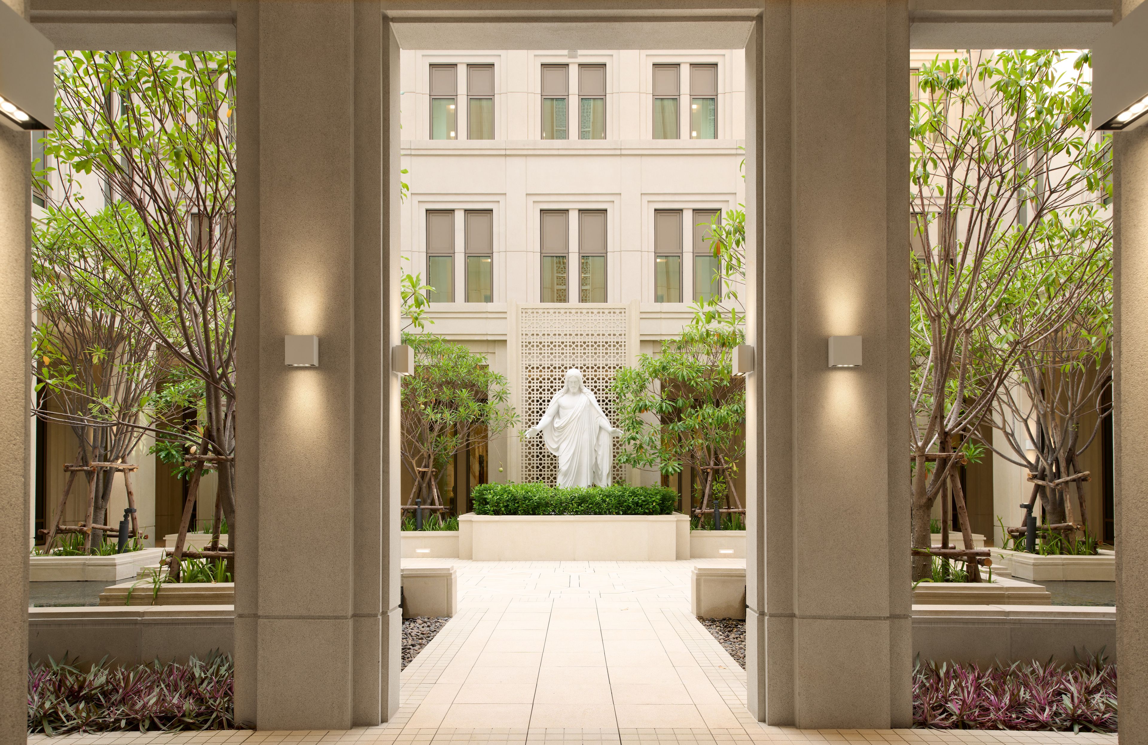 Images of the exterior of the Bangkok Thailand Temple. Images feature the architectural detail of the courtyard with a reflecting pong and Christus statue. 