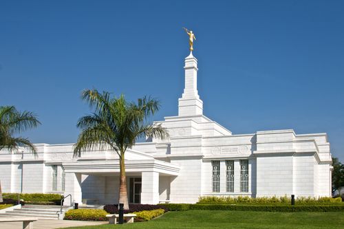 The front of the Oaxaca Mexico Temple on a warm day, with green lawns seen in the front on the right side.