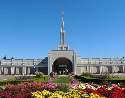 The front entrance to the Toronto Ontario Temple, with the grounds, including flowers and bushes.