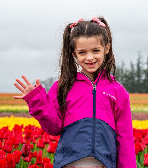 Girl waving in tulip field