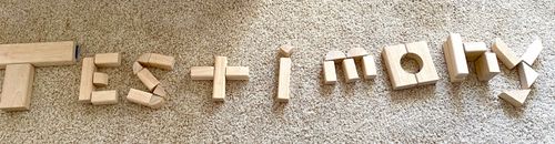 The word “testimony” spelled out with wooden blocks