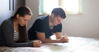 a wife and husband pray together