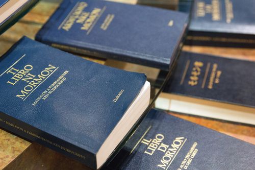 Copies of the Book of Mormon in various languages, with blue covers and gold writing, at the Independence Visitors’ Center in Missouri.