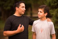 A man talking to a teenage boy in an outdoor setting.  Shot in Argentina.