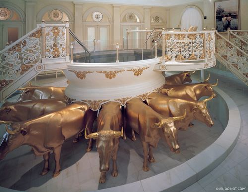 A white and gold baptismal font in the Salt Lake Temple held on the backs of 12 golden oxen.
