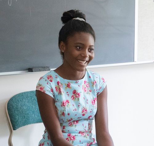 woman sitting with back to blackboard