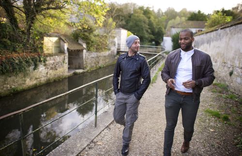 Cayo and Anthony walking alongside a waterway