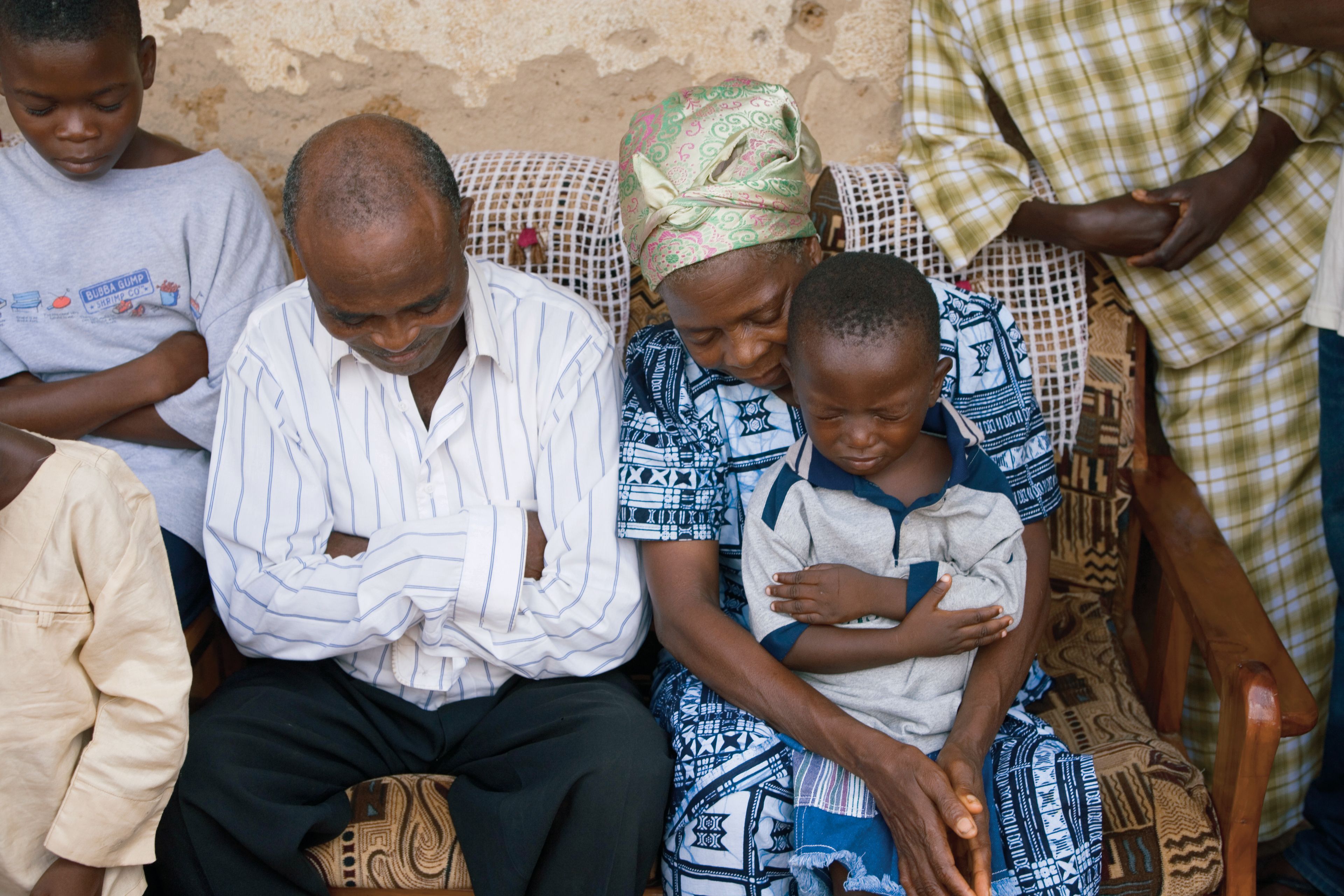 A family in Africa sitting and praying together.