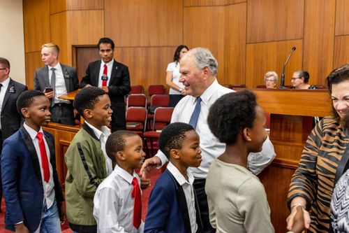 Elder and Sister Rasband shaking hands with children