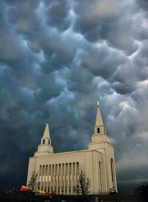 A view of the Kansas City Missouri Temple on a stormy day, looking up past the spires and into the gray clouds above.