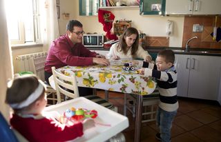 family at table, with one child in a high chair