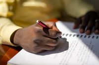 youth writing in notebook