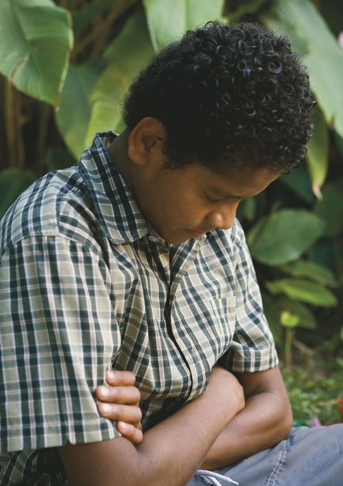 A young man in Fiji praying.