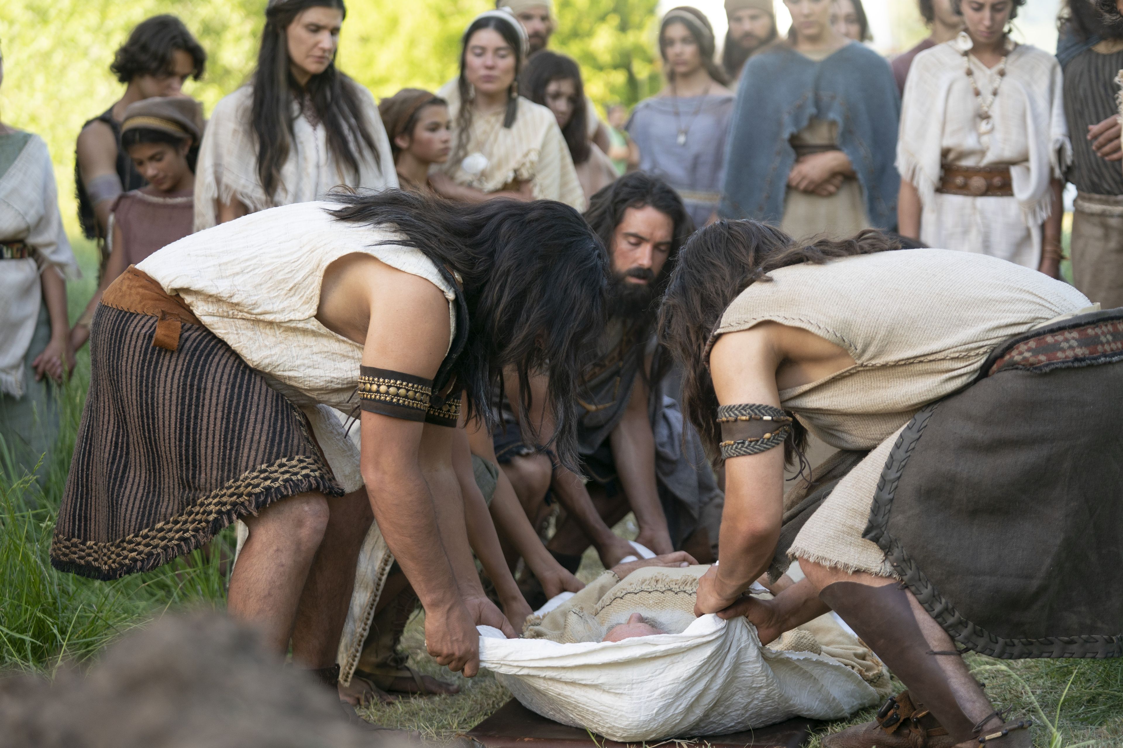 Lehi's family lowers his body into his grave.