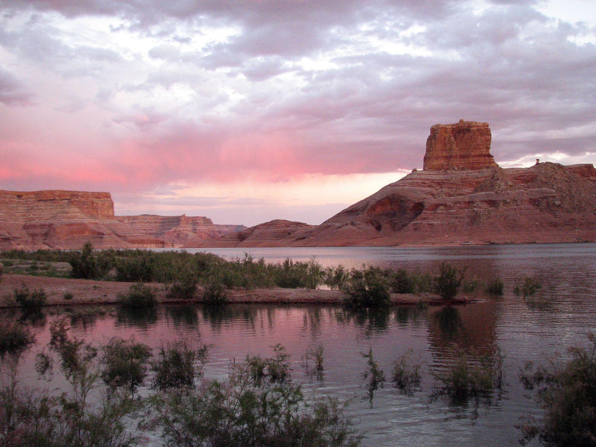 Red mesas line the edge of a lake.