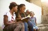 children and youth gathered around a book