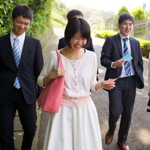 young people walking while holding name cards for the temple