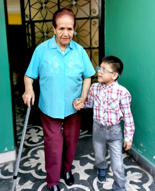 Rafael helping an elderly lady.