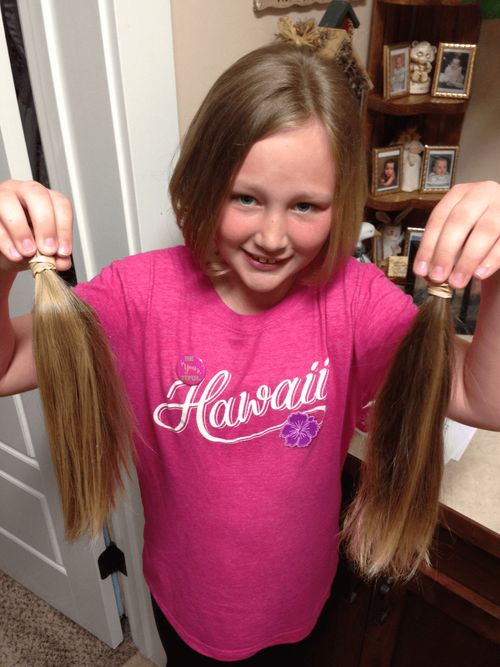 girl holding up hair she cut to donate