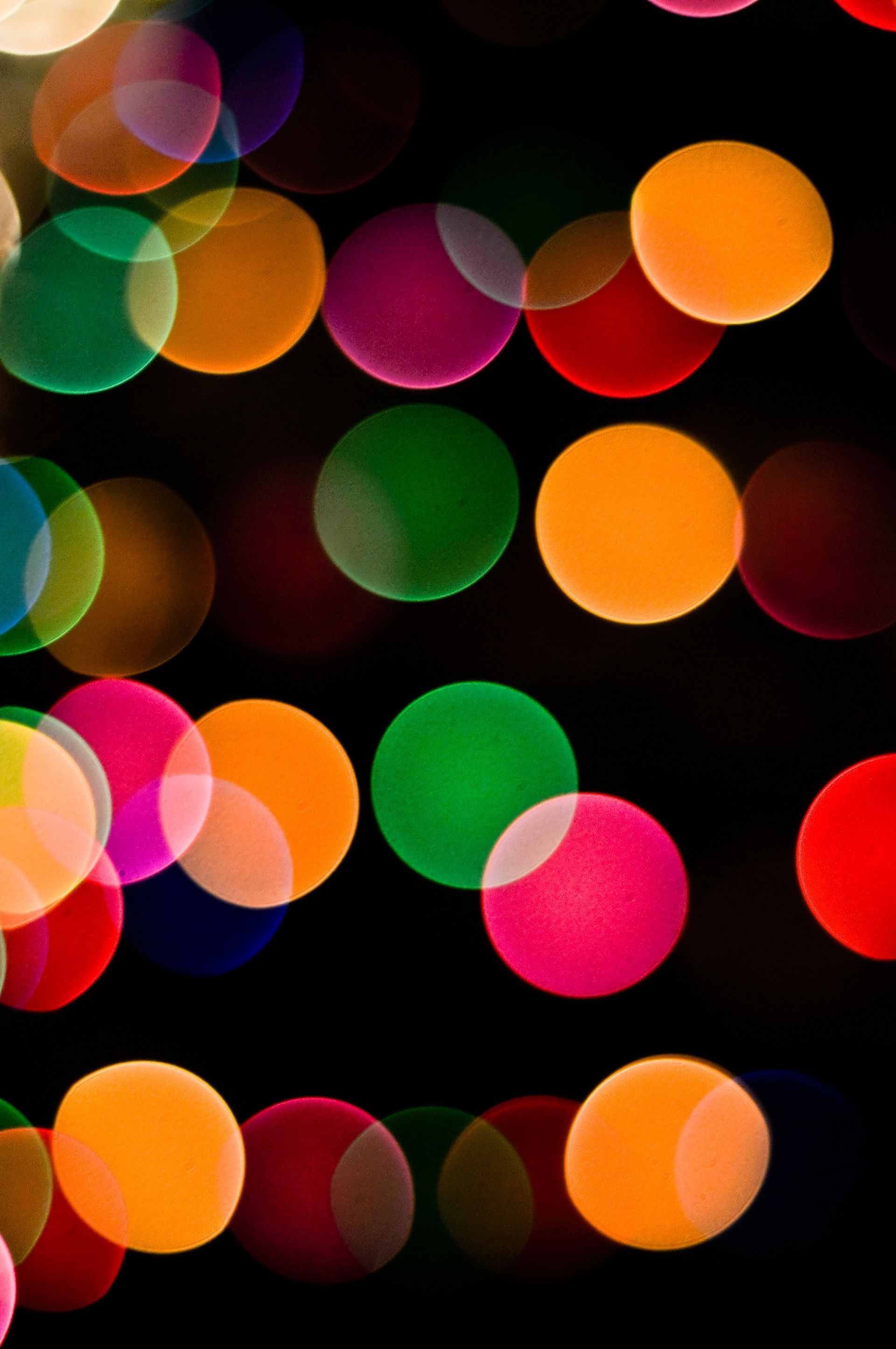Several different colors of lights blurred out into circles on a dark background.