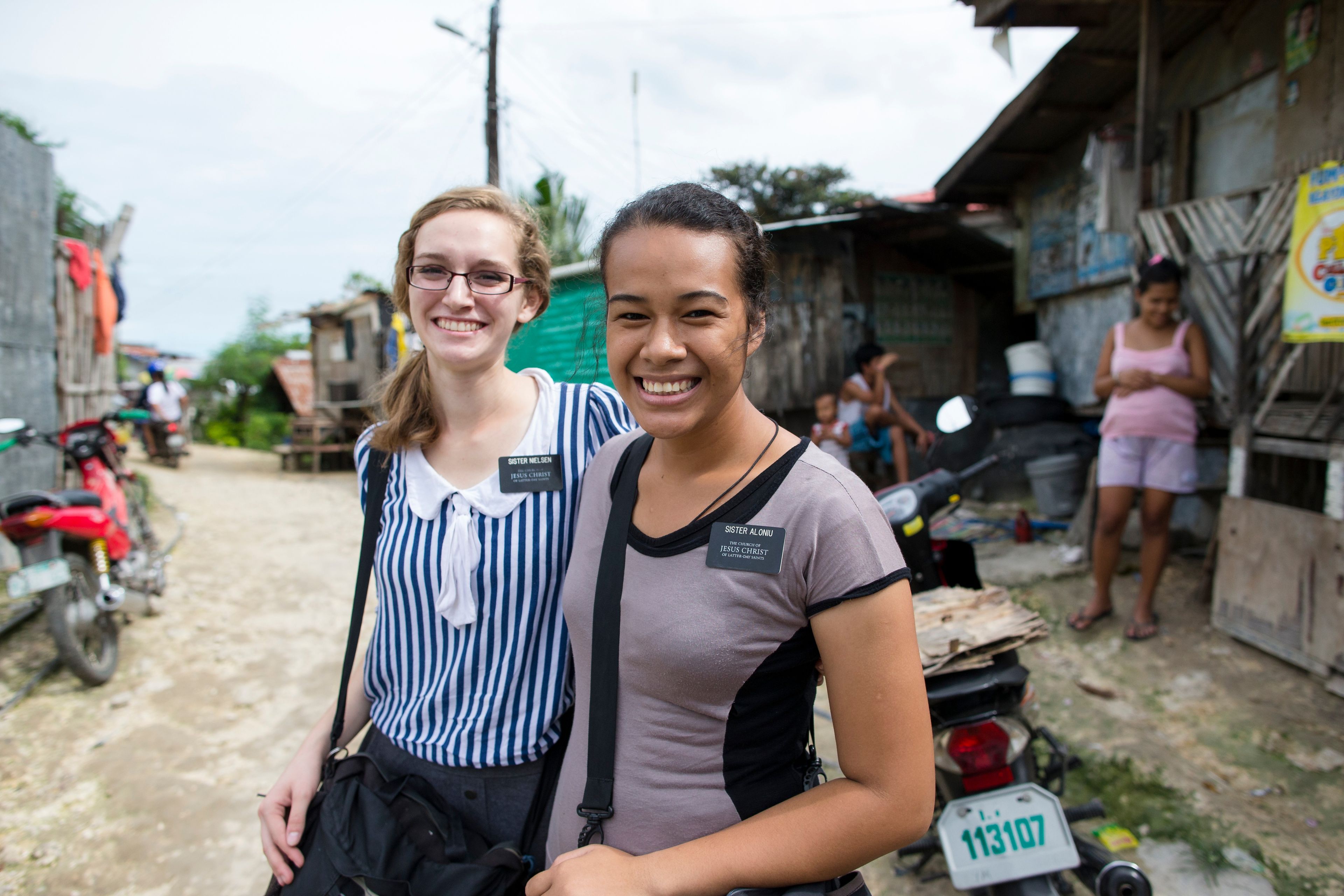 Two sister missionaries standing in a street in the Philippines.