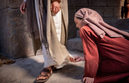 žena dodiruje skut Isusove halje