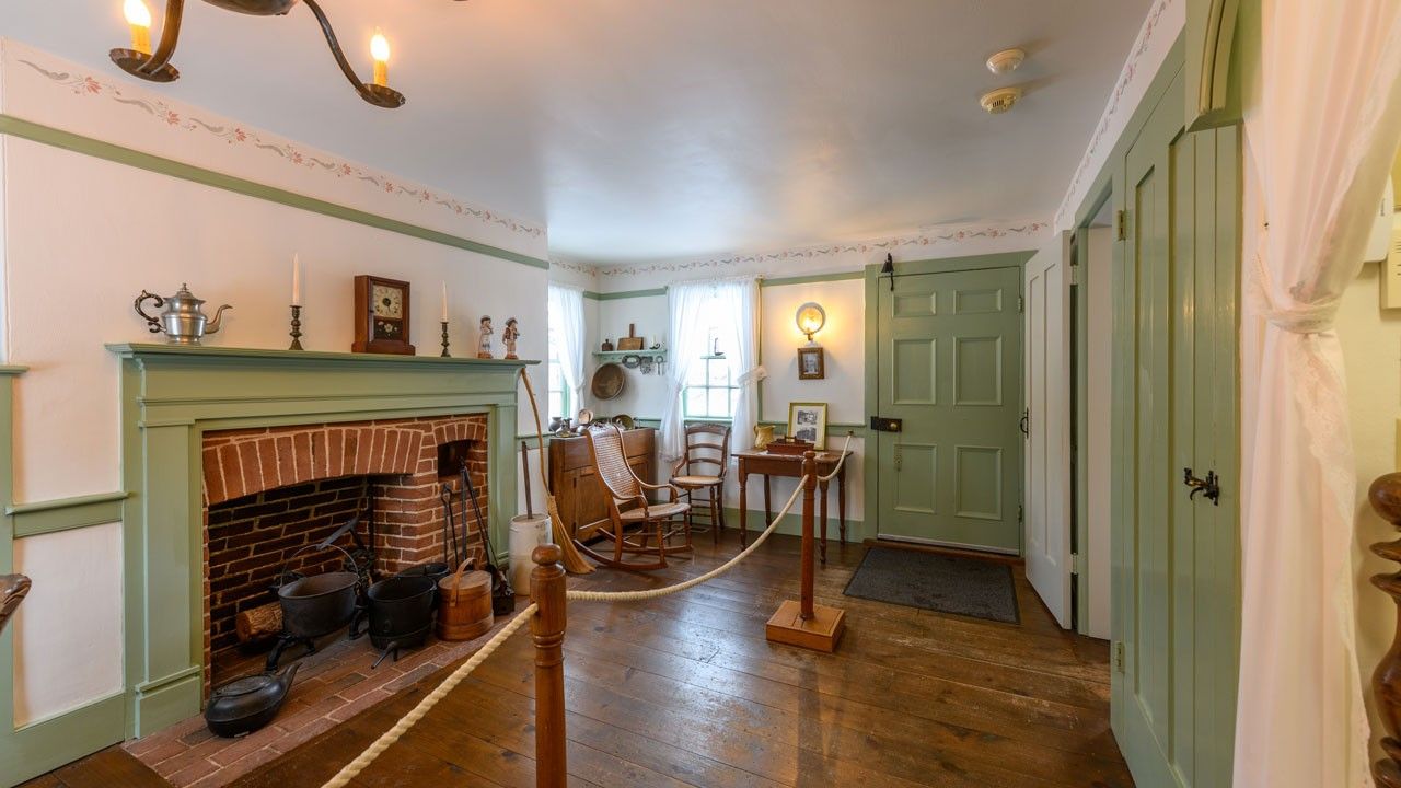 Parlor room with green-painted fireplace mantle, doors, and chair rail.