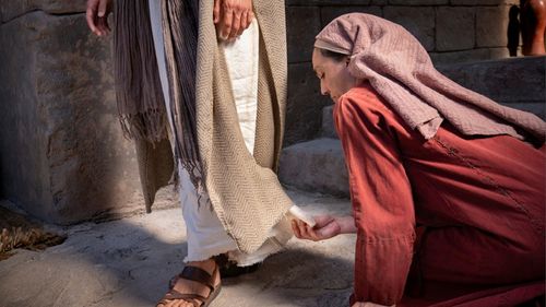 vrouw raakt de zoom van Christus’ bovenkleed aan