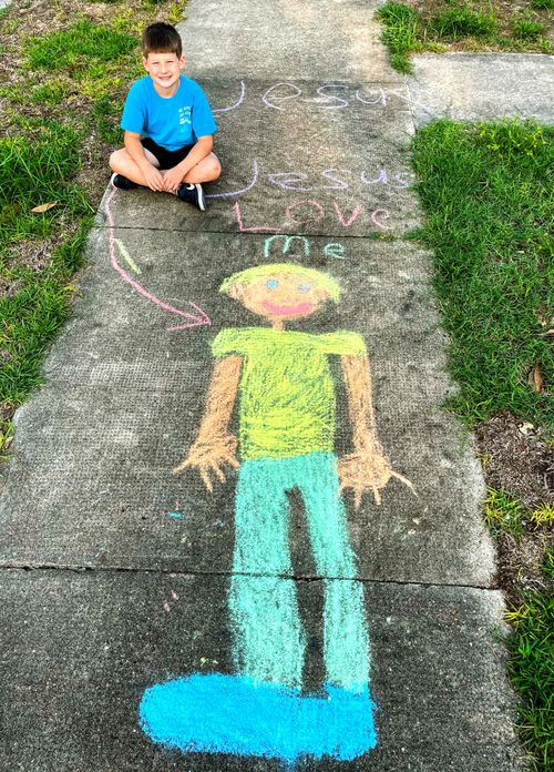 Child’s sidewalk chalk drawing of himself