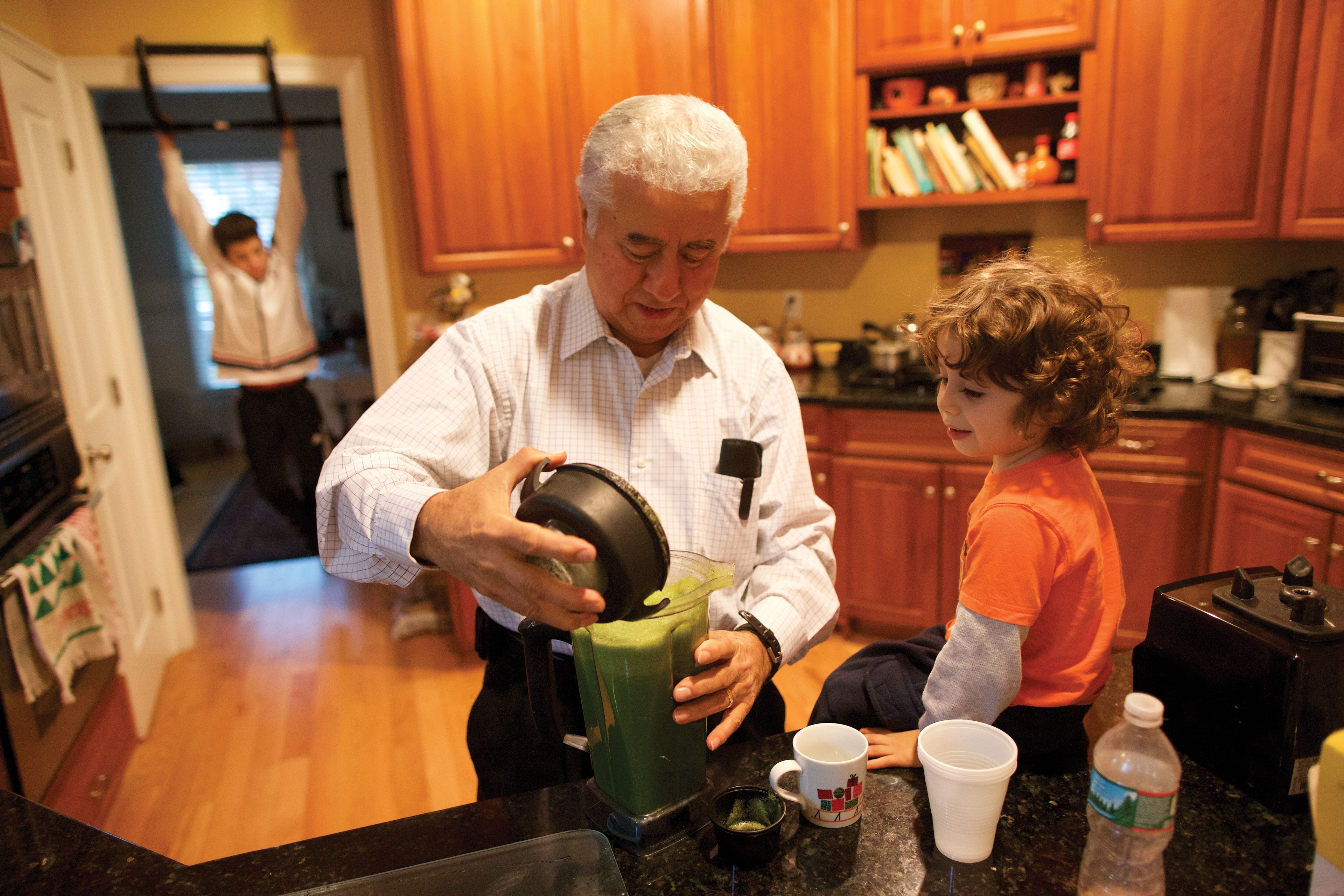 A man and his grandson making a smoothie in a kitchen in Boston.