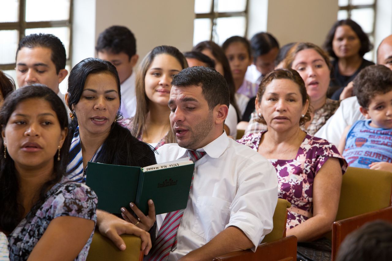Os membros da Igreja se cumprimentam durante uma reunião dominical desfrutando das bênçãos de Jesus Cristo