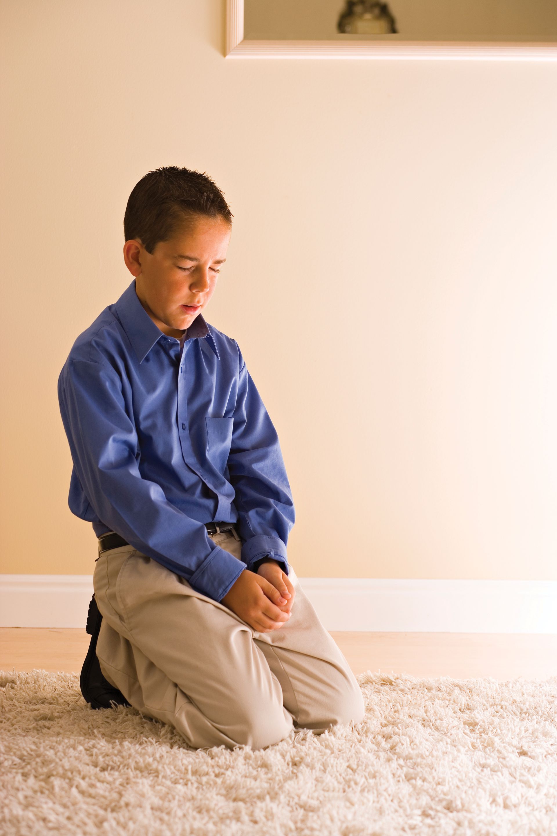 A boy kneels and prays.