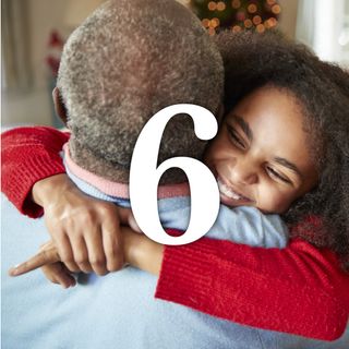 Granddaughter Giving Grandfather Hug As Multi Generation Family Celebrate Christmas At Home