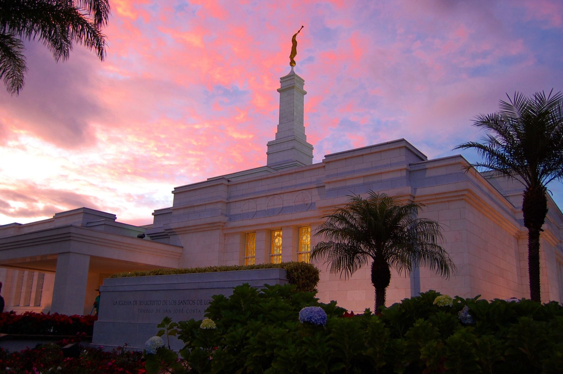 The San José Costa Rica Temple at sunset, including the entrance, name sign, and scenery.