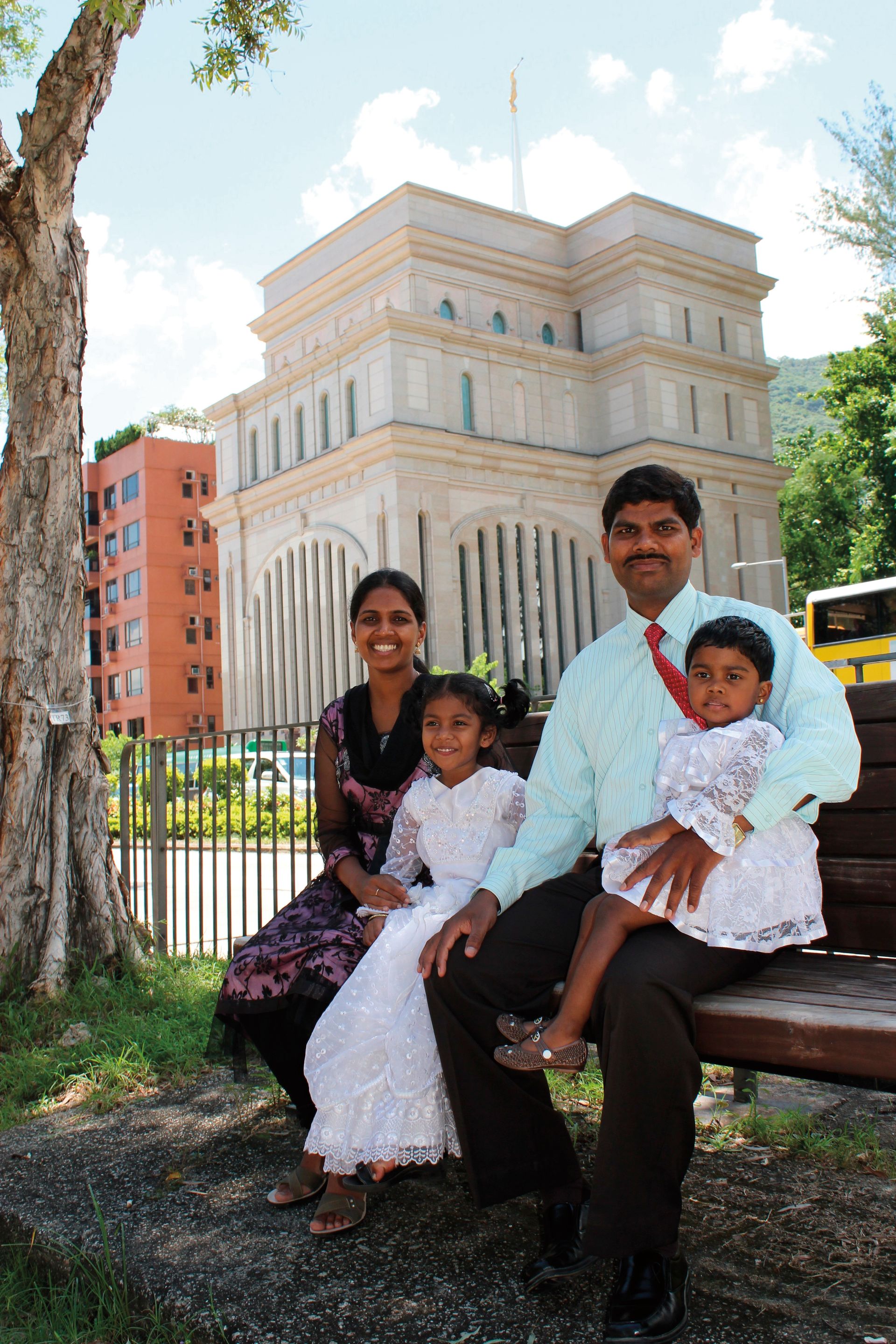 A family from India sitting outside the Hong Kong China Temple.