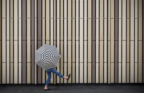 young adult walking with umbrella