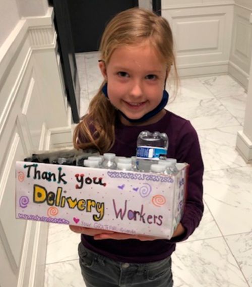 Ellie Rose McIntyre holds a box of bottled worker for emergency workers