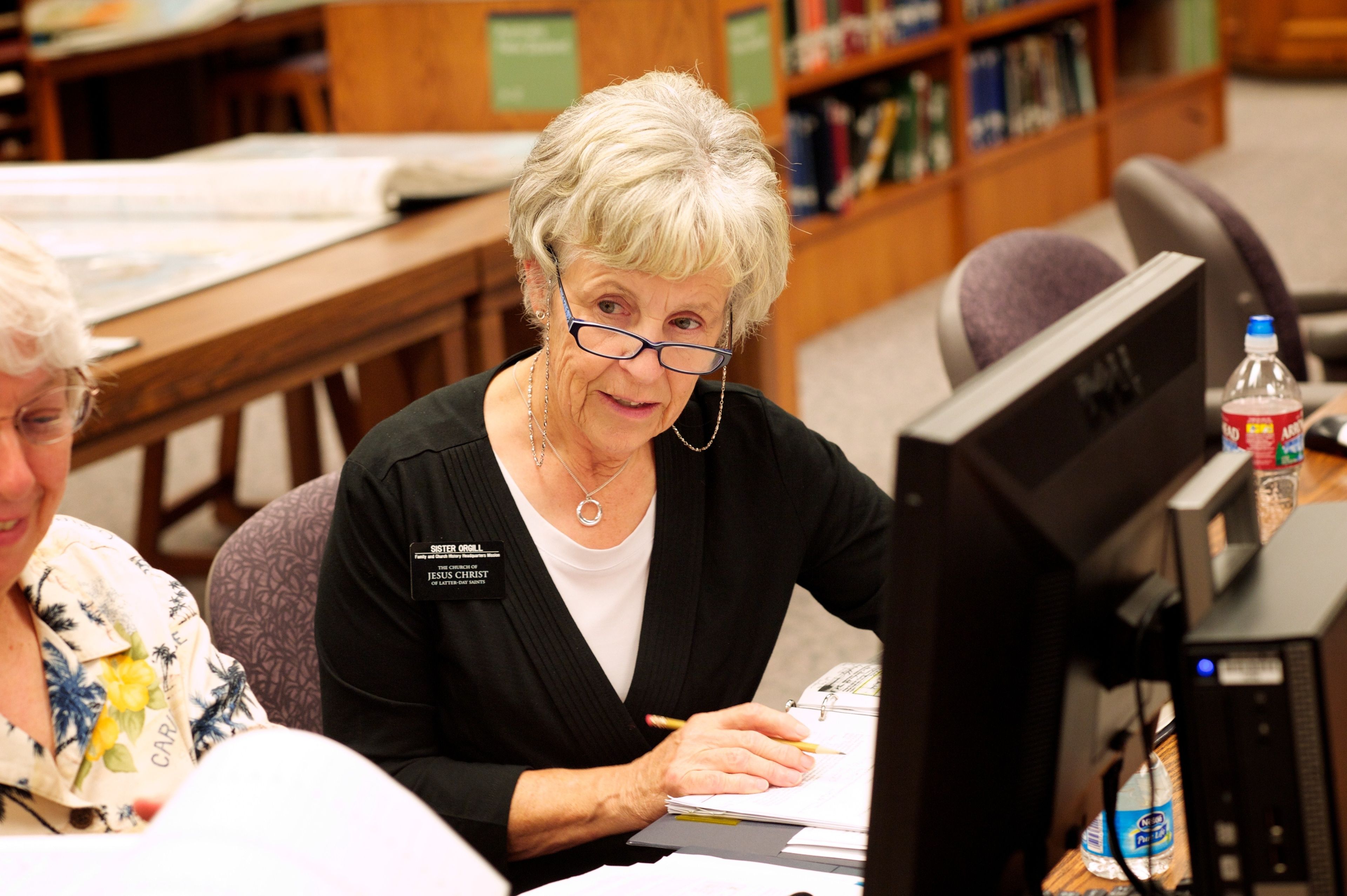 A senior Church-service sister missionary helps in the Family History Library.