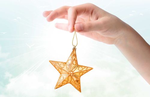 hand holding up a star ornament