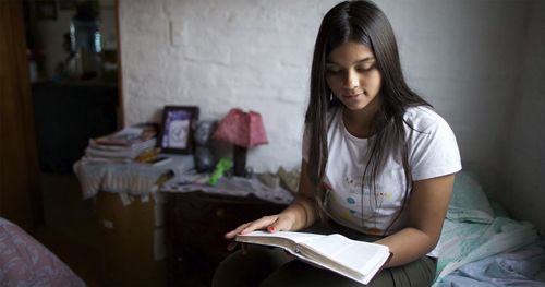 A young woman studying the scriptures.