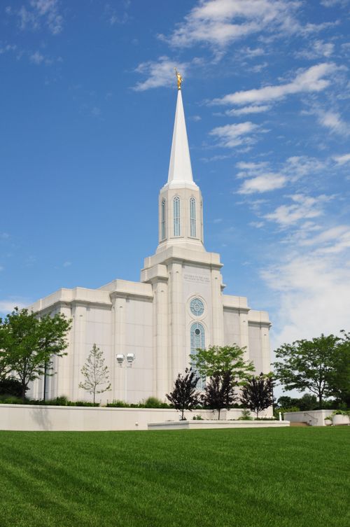 A view of the front of the St. Louis Missouri Temple, with a partial view of the grounds with trees.